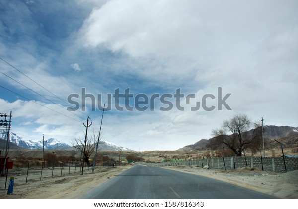 JAMMU KASHMIR, INDIA - MARCH 20 : View landscape beside\
road with Indian people drive car on Srinagar Leh Ladakh highway go\
to Confluence River at winter on March 21, 2019 in Jammu and\
Kashmir, India 