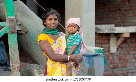 Jamshedpur, Jharkhand / India - 01 June 2020: Young Indian Woman Working At Construction Site With Her Baby In Her Lap
