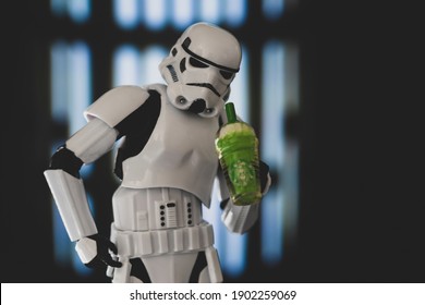 JAN 25 2021: Star Wars Imperial Stormtrooper looks down straw of a Starbucks Frappuccino - humor - Hasbro action figure