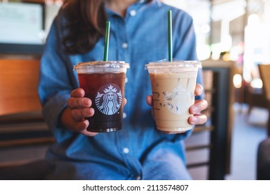 Jan 25th 2022 : Closeup of a woman holding two glasses of iced coffee at Starbucks coffee shop, Chiang mai Thailand 