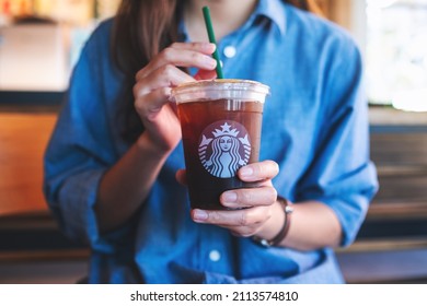 Jan 25th 2022 : Closeup of a woman holding and drinking iced coffee at Starbucks coffee shop , Chiang mai Thailand