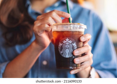 Jan 25th 2022 : Closeup of a woman holding and drinking iced coffee at Starbucks coffee shop , Chiang mai Thailan