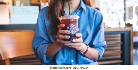 Jan 25th 2022 : Closeup of a woman holding and drinking iced coffee at Starbucks coffee shop , Chiang mai Thailand