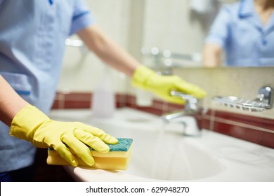 Janitor Cleaning Sink In Hotel Room