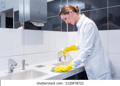 Janitor Cleaning Sink In Public Washroom With Cloth 