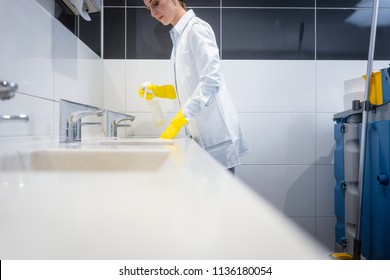 Janitor Cleaning Sink In Public Washroom With Cloth 