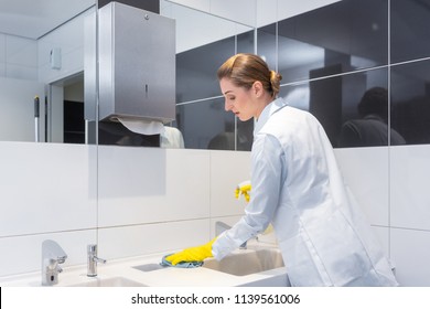 Janitor Cleaning Sink In Public Washroom With Cloth 