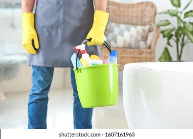 Janitor With Cleaning Supplies In Bathroom