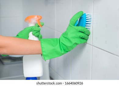 Janitor Cleaning Wall In Bathroom