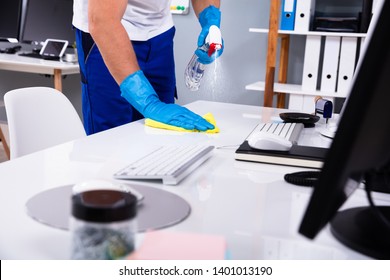 Janitor cleaning white desk in modern office - Shutterstock ID 1401013190