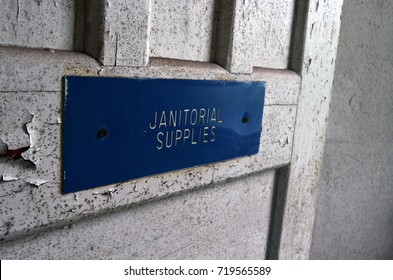 Janitor Closet Sign On White Weathered Peeling Door In Abandoned Business Building