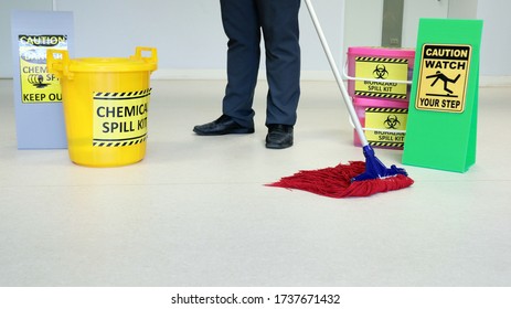 Janitor Male Cleaning Floor In Medical Service Room Or Laboratory With Caution Tag Sign Watch Your Step And Biohazard Spill Kit, Chemical Spill Kit Yellow Bucket For Response Chemical Spill Out Cases.