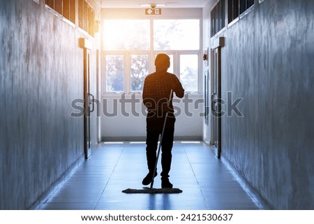 Janitor man mopping floor in dark hallway building or walkway silhouette working job with sun light background. Housekeeper or maid cleaner service concept.