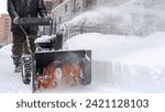 a janitor on a snowplow removes snow in the courtyard of a residential building. High quality photo