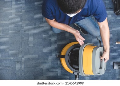 A Janitor Opens Up The Lid Of A Vacuum Cleaner To Inspect And Clean Out The Contents. At An Office Room.