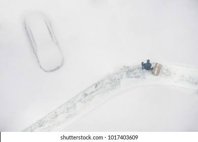 Janitor With A Shovel Cleans The Snow Of Parking Cars. View From Above 