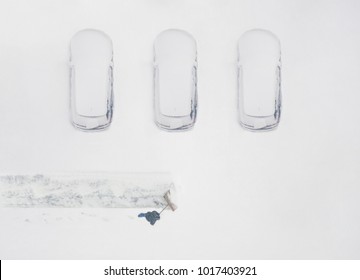 Janitor With A Shovel Cleans The Snow Of Parking Cars. View From Above 