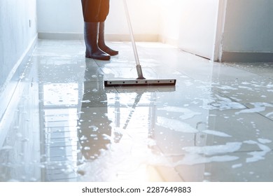 Janitor squeegee water on the floor hallway office building or walkway after school and classroom work job with sun light background. Wet floor or cleaning service house maid concept. - Powered by Shutterstock