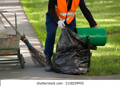 The Janitor Throws The Trash From The Urn In A Black Package