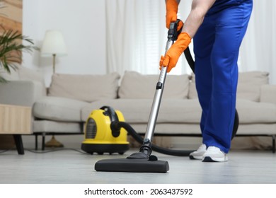 Janitor in uniform vacuuming floor indoors, closeup - Powered by Shutterstock