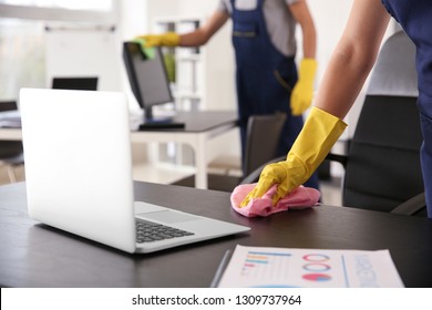 Janitor wiping table in office - Powered by Shutterstock