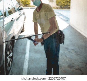 Janitor Worker Guy With Mask Cleaning Big Window Glass With Cleaning Tools In The Day