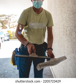 Janitor Worker Guy With Mask Cleaning Big Window Glass With Cleaning Tools In The Day