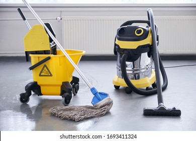 Janitorial service. Mop and bucket with professional vacum cleaner. - Shutterstock ID 1693411324