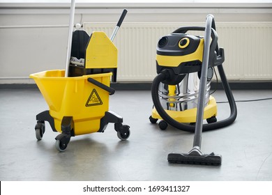 Janitorial service. Mop in bucket with professional vacum cleaner.