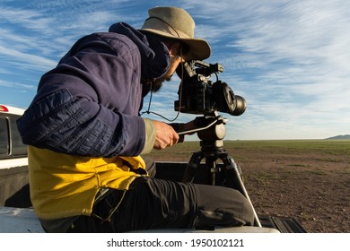 Janos, Chihuahua - AUGUST 17 2018: A Wildlife Cameraman Sits On The Back Of A Pick-up While He Shoots The Landscape. 