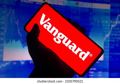 January 14, 2022, Brazil. In this photo illustration the Vanguard Group logo displayed on a smartphone screen and a stock market graph in the background