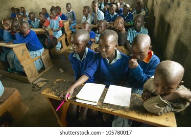JANUARY 2005 - Children in blue uniforms at school behind desk near Tsavo National Park, Kenya, Africa