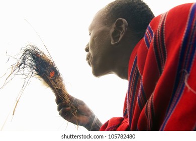 JANUARY 2005 - Masai Male Making Fire By Rubbing Sticks Together In Village Near Tsavo National Park, Kenya, Africa