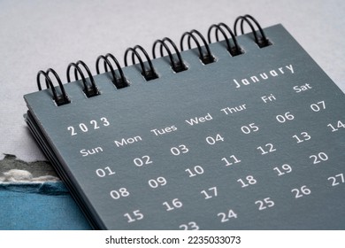 January 2023 - spiral desktop calendar  against textured paper, New Year, time and business concept
