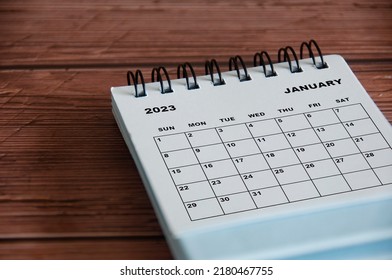 January 2023 white desk calendar on wooden table background. - Shutterstock ID 2180467755