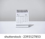 A January 2024 calendar desk for the organizer to plan and reminder isolated on white background, minimal style. White small table calendar with the page of the first month, Happy new year 2024.
