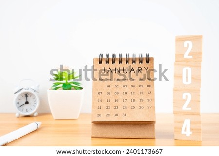 January 2024 desk calendar with wooden cubes show 2024 number on worktable.