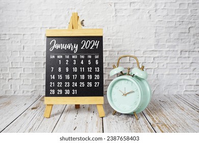 January 2024 monthly calendar on easel stand on wooden background