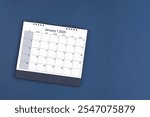 January 2025 Monthly desk calendar for 2025 year on blue color background, Position with copy space. Flat Lay.