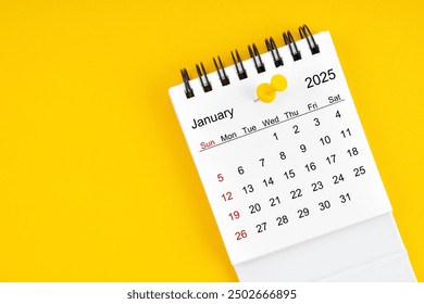 January 2025 Monthly desk calendar for 2025 year with thumbtack on yellow background.