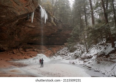 January 23rd - 2022 - Hocking Hills Ohio - United States.  A couple enjoys a moment near the waterfall at Ash Cave in Hocking Hills Ohio. 