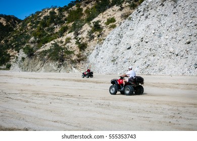 January 24, 2015.  Arroyo Buenos Aires, Baja California Sur, Mexico.  Two ATV Riders Race On Flat Sand Up A Dry Arroyo On The Southern End Of The Baja Peninsula.