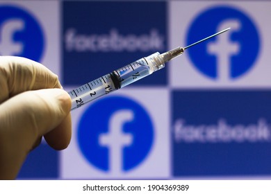 January 28, 2021, Brazil. In this photo illustration medical syringe seen with Facebook logo displayed on a screen in the background