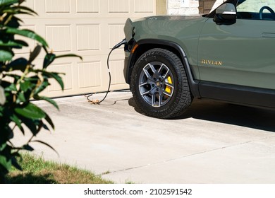 January 2nd , 2022 - Austin , Texas , USA:   Rivian R1T Electric Pickup Truck Charging at home on a Level 2 home charging station 
