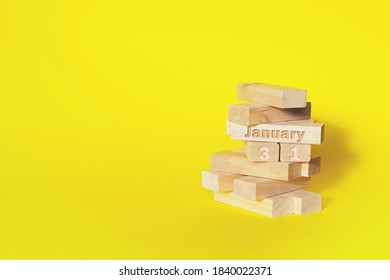 January 31st . Day 31 of month, Calendar date. Wooden blocks folded into the tower with month and day on yellow background, with copy space. Winter month, day of the year concept