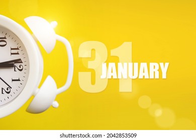 January 31st . Day 31 of month, Calendar date. White alarm clock on yellow background with calendar day. Winter month, day of the year concept