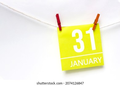 January 31st . Day 31 of month, Calendar date. Paper cards with calendar day hanging rope with clothespins on white background. Winter month, day of the year concept