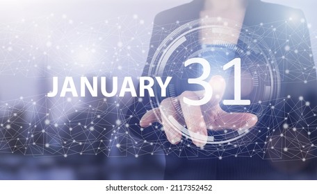January 31st . Day 31 of month, Calendar date. Hand click luminous hologram calendar date on light blue town background. Winter month, day of the year concept