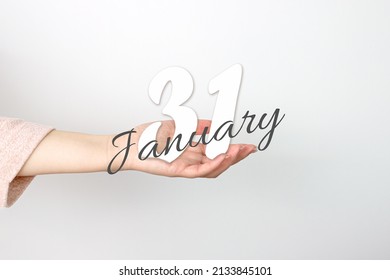 January 31st . Day 31 of month, Calendar date. Calendar Date floating over female hand on grey background. Winter month, day of the year concept