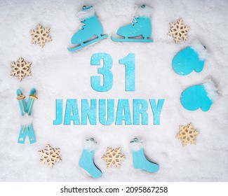 January 31st. Sports set with blue wooden skates, skis, sledges and snowflakes and a calendar date. Day 31 of month. Winter sports concept. Winter month, day of the year concept.